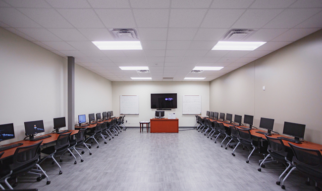 image of an empty computer classroom with computers and chairs