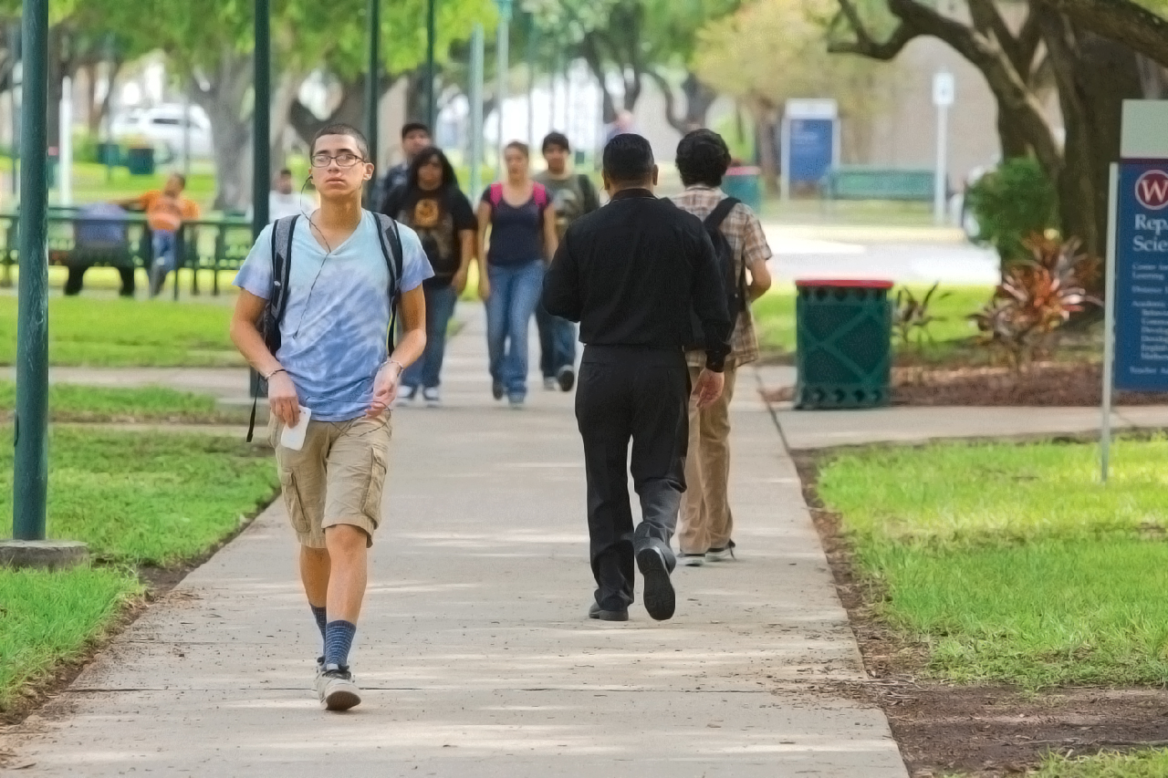 image of hispanic male student walking on campus