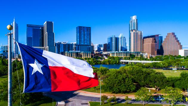 Texas flag with downtown in the background